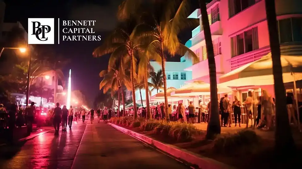 Illuminated Art Deco buildings and palm-lined street in Miami Beach